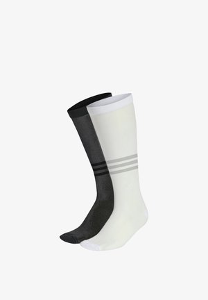Une chaussette noire et une blanche montantes au genou, chacune avec trois bandes horizontales autour du mollet.