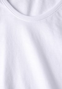 Weißer Baumwollstoff mit glatter Textur, runder Ausschnitt und sichtbaren Nähten. Einfaches und schmuckloses Design.