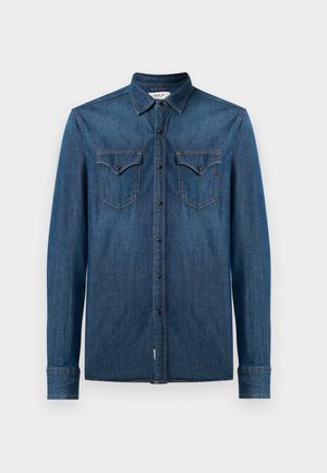 Camicia di jeans, blu scuro, con maniche lunghe e colletto a bottoni. Presenta due tasche sul petto con pattine e ricamo del logo.