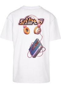 T-shirt blanc avec un graphisme coloré d'écouteurs et d'un lecteur cassette, agrémenté d'accents roses et oranges.