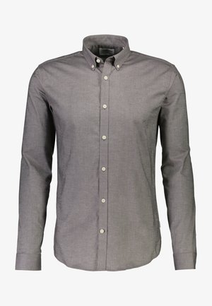 Chemise grise à manches longues avec un col classique, en tissu lisse et texturé, avec des coutures et des boutons visibles.
