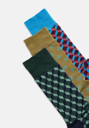 Tre paia di calzini con fantasia: uno blu uniforme, uno verde oliva con forme esagonali blu navy e uno marrone con pois turchesi e design geometrico rosso.