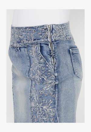 Gonna di jeans con vita alta, caratterizzata da ricami floreali argentati sul lato sinistro, chiusura con zip e una tasca posteriore. Tessuto blu chiaro.