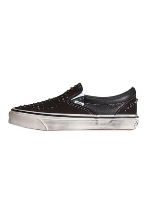 Sneaker Vans slip-on nere con borchie metalliche, suola in gomma bianca con segni di usura e dettaglio in pelle sul tallone.