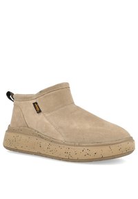 Scarpe slip-on in suede beige con un design alto e una suola in gomma beige maculata. Presentano un'etichetta nera sul retro.