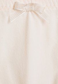 Tessuto color crema con una texture liscia, che presenta un nastro traslucido a fiocco come decorazione superiore e un dettaglio di bordo cucito.