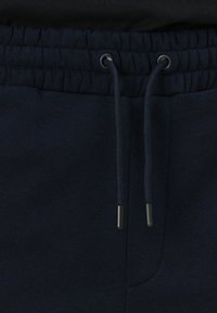 Navyblaue Jogginghosen mit elastischem Bund und Kordelzug, flachen Nähten und einer glatten Baumwolltextur.