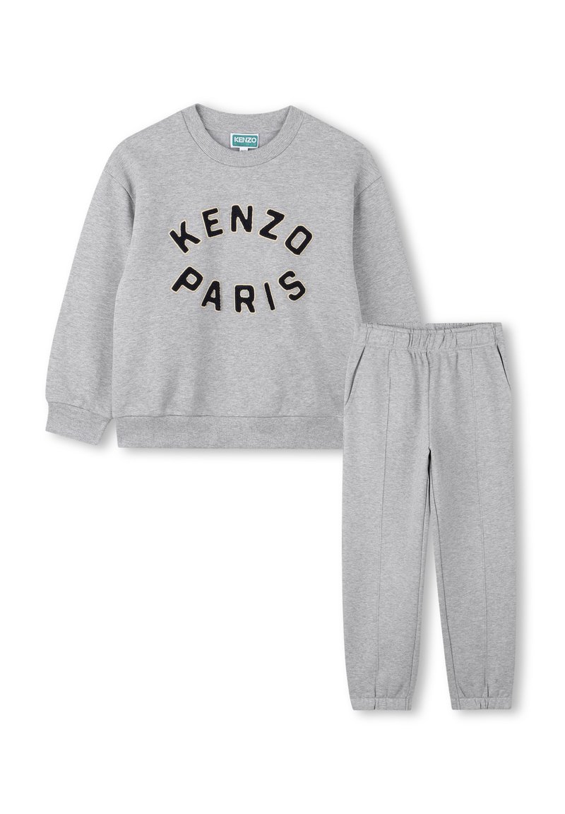 Ensemble sweat-shirt et pantalon gris avec le texte "KENZO PARIS" sur le devant du sweat-shirt, poignets élastiques et taille élastique sur le pantalon.