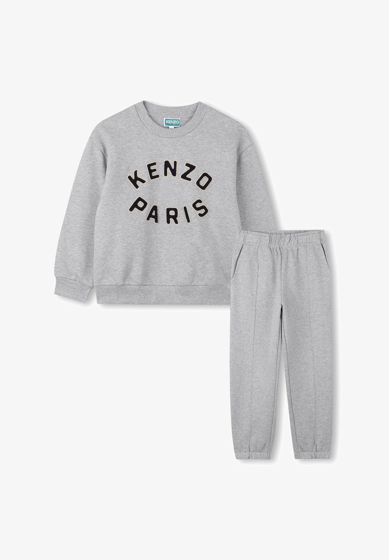 Ensemble sweat-shirt et pantalon gris avec le texte "KENZO PARIS" sur le devant du sweat-shirt, poignets élastiques et taille élastique sur le pantalon.