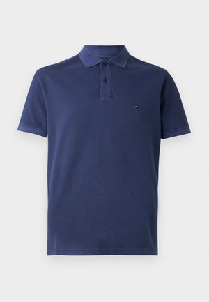 Navyblå pikétröja gjord av bomull, med krage, korta ärmar och en liten logotypdetalj på vänster bröst.