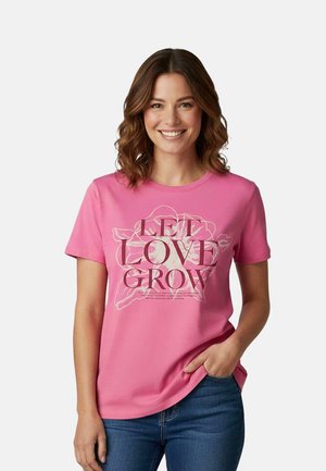 Roze katoenen T-shirt met een bloemenafbeelding en de tekst "LET LOVE GROW" in gedurfde, contrasterende kleuren. Korte mouwen en een ontspannen pasvorm.