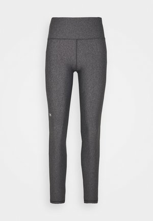 Leggings de sport gris avec une taille haute, fabriqués en tissu texturé et extensible, arborant un petit logo sur la cuisse gauche.