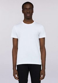 Bílé bavlněné tričko s kulatým výstřihem a krátkými rukávy, s přiléhavým střihem a hladkou texturou, zobrazené na modelce.