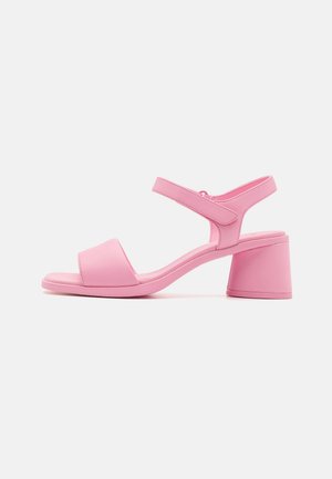Sandali con tacco rosa realizzati in un materiale sintetico liscio, design a punta quadrata, cinturino alla caviglia e tacco largo.