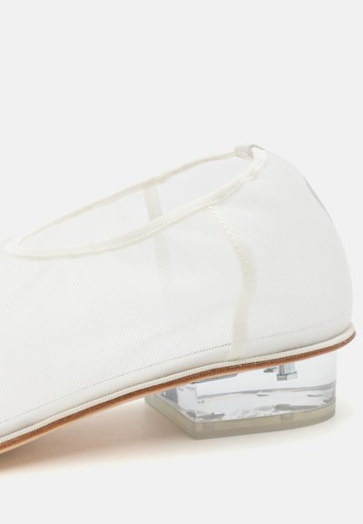 Valge võrgust balletiking, millel on läbipaistev plokknina. Sile tekstuur, ümar kuju ja minimalistik disain rõhutavad jalatsite elegantsi.