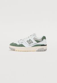 Zapatilla blanca y verde con materiales de ante y piel, que presenta una forma elegante, cordones en la parte delantera y una suela de goma de contraste.
