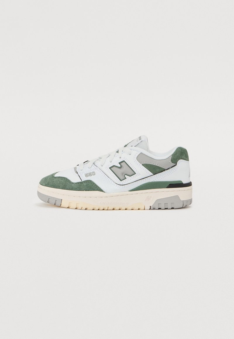 Zapatilla blanca y verde con materiales de ante y piel, que presenta una forma elegante, cordones en la parte delantera y una suela de goma de contraste.