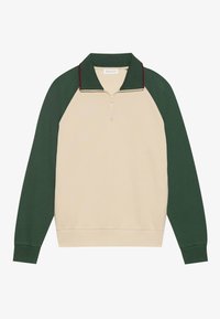 Suéter crema con mangas raglán verdes, cuello con cremallera y ribete burdeos en el cuello. Textura suave con puños y dobladillo acanalados.