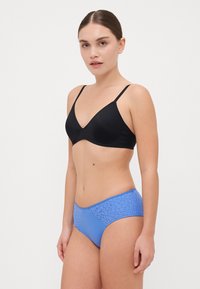 Soutien-gorge noir avec des bretelles fines et un design en V, associé à une culotte bleue avec un motif texturé sur le dessus. Fini en tissu lisse.