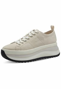 Sneaker beige in tela con lacci bianchi, punta rotonda e suola in gomma nera spessa; presenta una texture rigata sul bordo della suola.