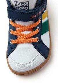 Baskets avec une tige bleu marine, un bout blanc, des lacets orange, et des rayures jaunes, vertes et blanches. Présente des accents cousus et une semelle en caoutchouc.