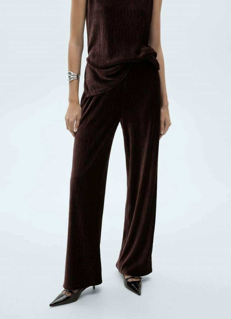 Bordeaux ribbed twee-delig outfit met een losse top met gedrapeerde details en wijde broekspijpen, gecombineerd met puntige zwarte hakken.