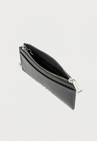 Schwarze Lederbrieftasche mit strukturierter Oberfläche, ausgestattet mit einem silbernen Reißverschluss und Zuglasche, teilweise geöffnet, um das Innere zu zeigen.