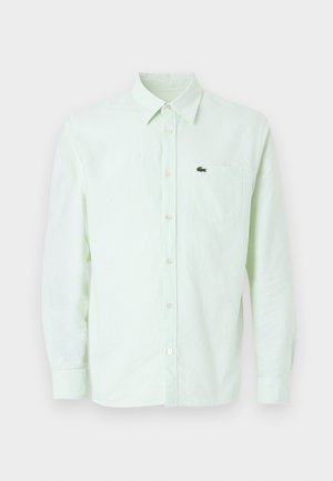 Light green and white striped long-sleeve button-up shirt with collar and chest pocket featuring a small crocodile logo.