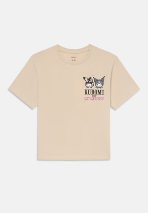 T-shirt beige à manches courtes avec un col rond, présentant un imprimé graphique de deux personnages de dessins animés, Kuromi et My Melody, sur la poitrine.