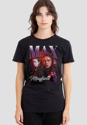 Young woman wearing a black T-shirt featuring three portraits of Max Mayfield with red and purple graphic accents.