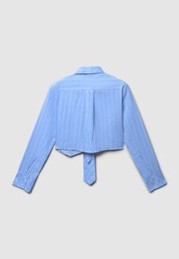 Chemise courte bleu clair avec des rayures verticales blanches, manches longues, poignets boutonnés et un détail de nœud au dos. Texture de tissu lisse.