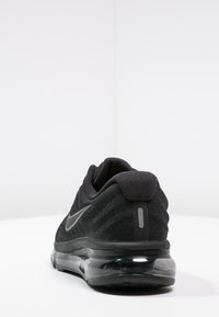 Sneaker nera Nike con tomaia in tessuto intrecciato, colletto imbottito e suola d'aria trasparente per un'ottima ammortizzazione. Logo discreto sul lato.