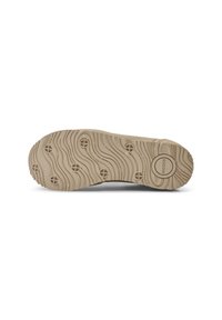 Bežna potplat tenisica s valovitom teksturom, kružnim uzorcima i kružnim logotipom označenim s "WOODEN". Prikazuje značajke prianjanja i trakcije.