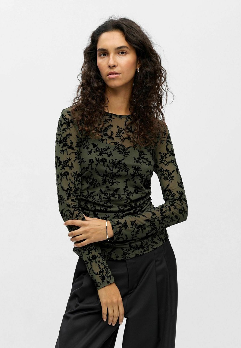 Long-sleeve top in olive green with a sheer floral pattern in black; smooth texture with fitted design and crew neckline.