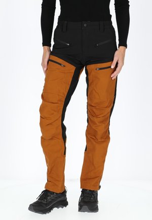 Waterproof outdoor pants featuring black and orange color blocks, multiple zippered pockets, and a fitted design for mobility.