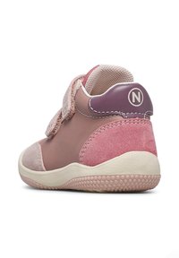 Zapatos infantiles en rosa y malva con una correa de velcro, materiales de ante y malla, forma redondeada y suela de goma texturizada.