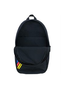 Mochila de tela negra con forma redondeada, que presenta un acento de franjas en rojo, amarillo y azul en el costado y un interior vacío.