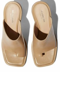 Beige leren slip-on sandalen met een vierkante neus, open achterkant en een minimalistisch ontwerp. Kenmerkt zich door een subtiele uitsnijding op de bovenkant.
