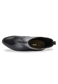 Botín de cuero negro hasta el tobillo con puntera afilada, paneles laterales elásticos y una abertura con acentos dorados. Textura suave y diseño minimalista.