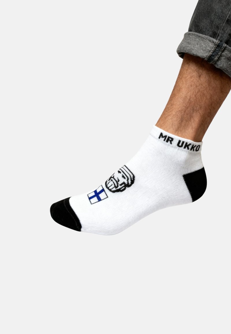 Calcetín blanco de tobillo con acentos en negro. Presenta un gráfico de un hombre con barba y una bandera finlandesa. Texto "MR UKKO" cerca del puño.