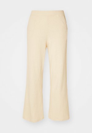 Pantalones de pierna ancha en beige claro con un tejido texturizado, que cuentan con una cinturilla elástica y dos bolsillos laterales.