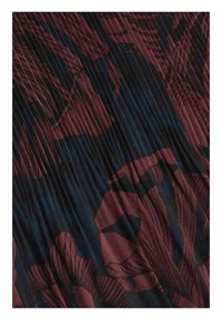 Fållad tyg i rik burgund och djup blå, med abstrakta blommönster. Mjuk textur med ett flytande mönster.