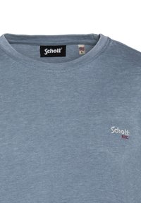 T-shirt in cotone azzurro chiaro con colletto a giro e maniche corte. Presenta un piccolo logo ricamato "Schott NYC" in rosso e bianco. Taglia L.