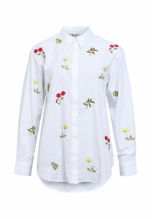 Chemise à col blanc avec broderie florale en rouge, jaune et vert. Manches longues et ourlet arrondi. Fabriquée en tissu de coton.