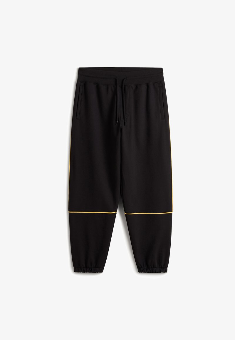 Svarta joggingsbyxor i mjukt material, med dragsko i midjan, sidofickor och gult kantband vid fållen. Elastiska muddar.