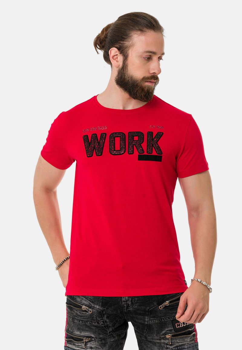 Rotes Baumwoll-T-Shirt mit kurzen Ärmeln, das mit dem auffälligen schwarzen Text "WORK HARD" versehen ist. Glatte Textur, runder Halsausschnitt, taillierte Passform.