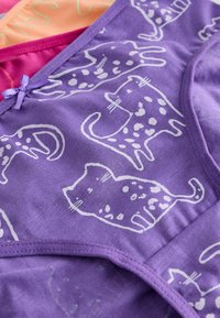 Paarse katoenen kledingstuk met een volledig witte kattenprint. Aangevuld met lavendelkleurige accentdetails en een klein strikje bij de halslijn.