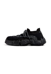 Black and gray knitted sneaker with thick textured sole, black and white speckled laces wrapped around the shoe and tied in a bow.