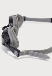 Zwemgogen met een gestroomlijnd ontwerp, zwarte lens, grijze siliconen rand en een band met een reliëfdetail met de tekst "JUST DO IT".