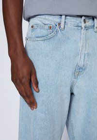 Ljusblå jeans i denim, med rak legsnitt, kopparfärgade nitknappar, fem fickor och en något blekt finish.